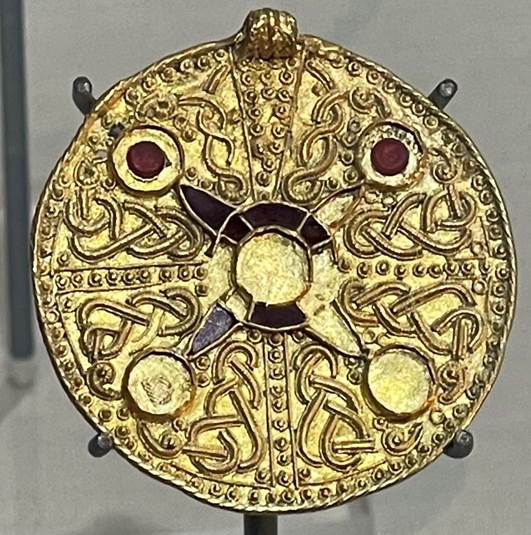 A gold circular object with a circular design
Description automatically generated with medium confidence